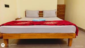 a bedroom with a bed with a red blanket on it at The Haira Retreat in Kappil