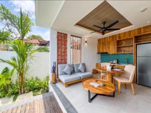 a kitchen and living room with a table and a couch at The Arca Villas by GenuineHost in Sanur