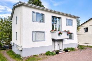 a white house with flowers in a window at Katariina Apartments in Kotka