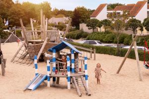 two children playing on a playground in the sand at Summio Parc Port Greve in Brouwershaven