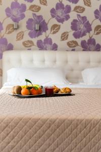 a tray of fruit sitting on a bed at Hotel Bruman in Caserta