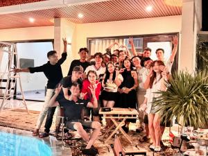 a group of people posing for a picture next to a pool at Homestay coffee Hoàng Nhạn in Mỹ Hòa (1)