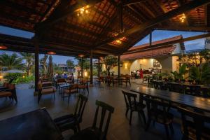 a restaurant with tables and chairs and a bar at Homestay coffee Hoàng Nhạn in Mỹ Hòa (1)
