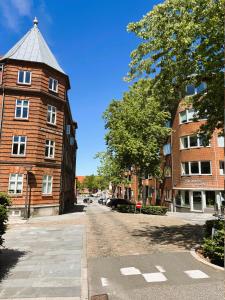 a building with a tower on the side of a street at Vejle Liv in Vejle