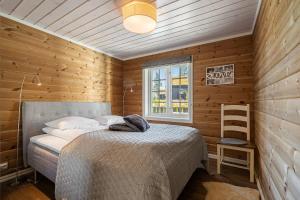 a bedroom with a bed and a wooden wall at Solsiden 16B by Vacation Trysil in Trysil