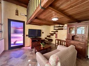 a living room with a couch and a tv and stairs at La Casa di Ori in Castel SantʼElia +6 photos