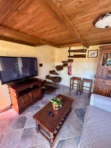 a living room with a tv and a couch and a table at La Casa di Ori in Castel SantʼElia