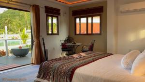 a bedroom with a large bed and a balcony at This Great Place in Don Sak