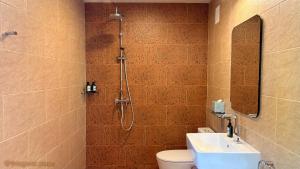 a bathroom with a shower and a toilet and a sink at This Great Place in Don Sak