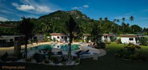 a resort with a pool and a mountain in the background at This Great Place in Don Sak