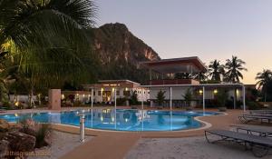 a hotel with a swimming pool in front of a mountain at This Great Place in Don Sak +76 photos
