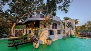 a house with a green floor and a building at Mango Tree House Yala Safari Hotel in Tissamaharama