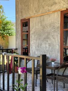 a patio with a table and chairs and a stone wall at Lanta natural hut garden in Ko Lanta