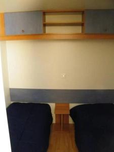 a bedroom with two beds and wooden shelves at Camping 3 étoiles - Piscine - ccbfeb0 in Mayrac