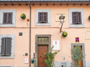 a pink building with a wooden door and windows at SOHO Borgonovo by Dasso - Case Vacanze e Appartamenti in Viterbo