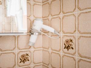 a bathroom with a blow dryer on a tiled wall at Familienzimmer Nr 1 im Haus Sabine in Braunlage +13 photos