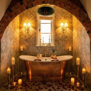 a bathroom with a tub with candles in it at Weston Manor Hotel in Bicester