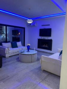 a living room with two white couches and a fireplace at Dar Selima Hammamet in Hammamet