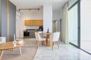 a kitchen and dining room with a table and chairs at Prestige 402 1 BED in Paphos