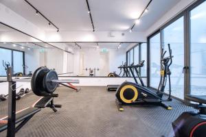 a gym with treadmills and ellipticals in a room with windows at Prestige 402 1 BED in Paphos