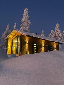 a log cabin in the snow at night at Mystical Lapland Suite in Rovaniemi