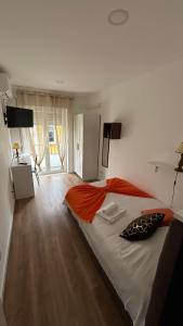 a bedroom with a large bed with an orange blanket at Alojamento Numara in Setúbal