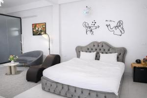 a bedroom with a large bed and a chair at Mèn Mén Home in Phú Thọ
