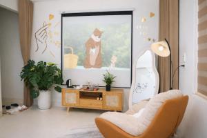 a living room with a picture of a cat on the wall at Mèn Mén Home in Phú Thọ