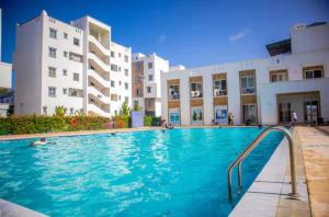 a swimming pool in front of a building at Leona Homes in Mombasa