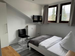 a bedroom with a bed and a chair in it at Oberkasseler Hof Bonn in Bonn