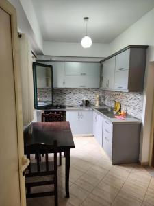 a kitchen with white cabinets and a table in it at Apartment 2 by Villa Ceni in Elbasan