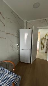 a kitchen with a white refrigerator in a room at Alojamento Numara in Setúbal