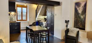 a kitchen with a table and a dining room at Maison cosy 4-6 pers avec terrasse Lac & hyper centre à pied 300 m Linge inclus in Gérardmer