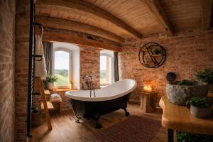 a bathroom with a bath tub in a brick wall at Apartamenty Dworzec Tleń in Tleń