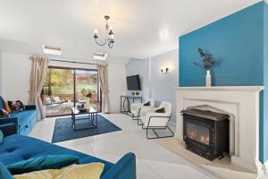 a living room with a fireplace and a blue wall at Northbrook in Tackley
