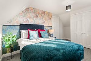 a bedroom with a large bed with a blue blanket at Northbrook in Tackley