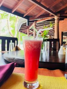 a drink in a glass sitting on a table at Hotel Kamrel Sigiriya in Sigiriya
