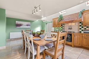a kitchen and dining room with a wooden table and chairs at Northbrook in Tackley +16 photos