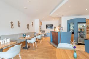 un ristorante con sedie e tavoli bianchi e scarpe sul muro di Hotel Strandhus a Cuxhaven