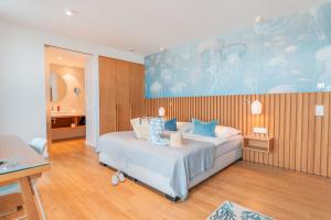 una camera da letto con un letto con cuscini blu di Hotel Strandhus a Cuxhaven Altre 38 foto