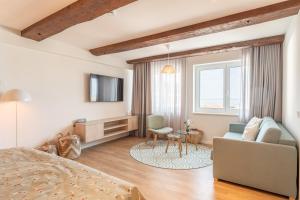 una camera da letto con un letto, un divano e una TV di Hotel Strandhus a Cuxhaven
