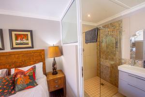 a bedroom with a bed and a shower and a sink at The Paper Fig House in Plettenberg Bay +104 photos