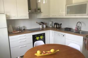 a kitchen with a table with a bowl of fruit on it at Grande maison proche plage et centre ville avec grand parking in Quiberon