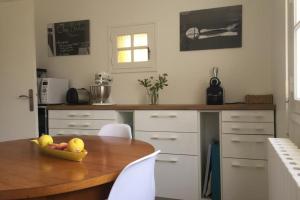 a kitchen with a table with a bowl of fruit on it at Grande maison proche plage et centre ville avec grand parking in Quiberon