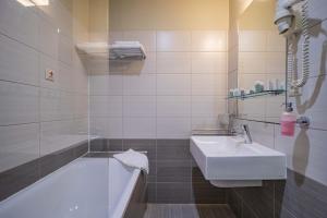 a white bathroom with a tub and a sink at AR Golden House II in Košice