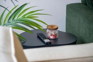 a table with a remote control and a jar on it at Station Gold Leaf - Gym - Games Room - MK in Milton Keynes