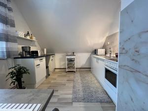 a kitchen with white cabinets and a table in it at Ferienwohnung Balkon Grupe in Stadtoldendorf