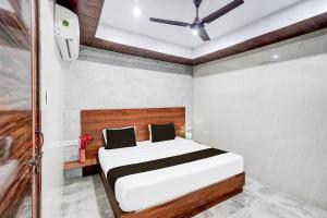 a bedroom with a bed and a ceiling fan at Hotel O Govind Nagar Kanpur Formerly Maharoopa Palace in Kānpur