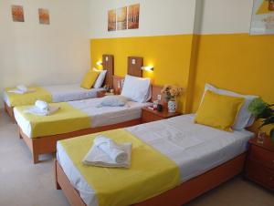 three beds in a room with yellow walls at on the STRIP studio 3 in Kavos +20 photos