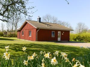 a red house with flowers in front of it at Lachmöwe in Munkbrarup
